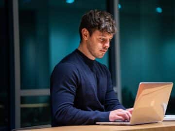 man in black long sleeve shirt using macbook