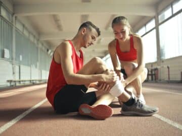 Woman Wrapping Man's Leg with Bandage