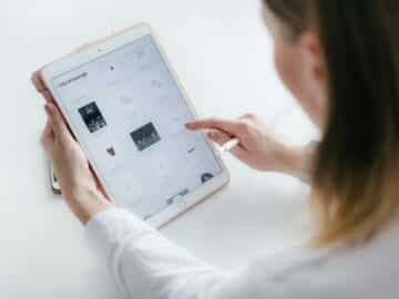 Woman Sitting Beside Table While Using Ipad