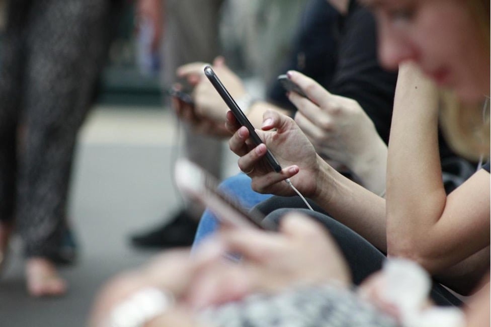 Multiple people receiving messages on their mobile phones, using text messaging for nonprofits to enhance donor engagement and drive long-term support