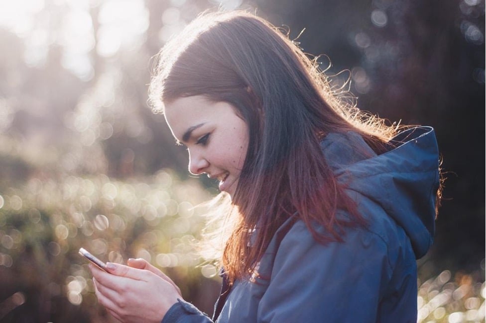 A woman sending an SMS reminder about an upcoming event to nonprofit volunteers.