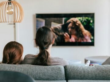 a couple of women sitting on top of a couch