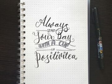 white spiral book with text print beside black pen