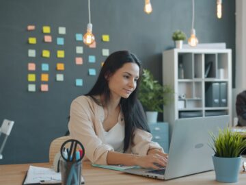 Woman working on laptop in modern office space