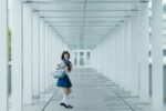Schoolgirl poses in a white hallway.