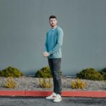 a man standing in front of a gray wall