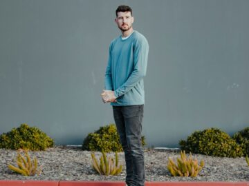 a man standing in front of a gray wall