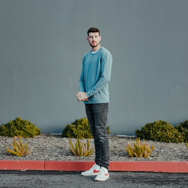 a man standing in front of a gray wall