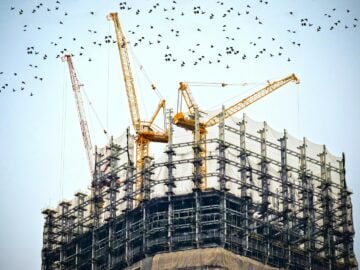 low angle photography of cranes on top of building