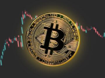 a bitcoin is shown in front of a stock chart