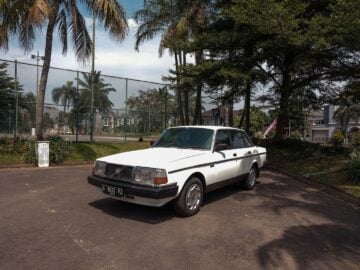 a white car parked in front of a fence. Can You Lease a Used Car