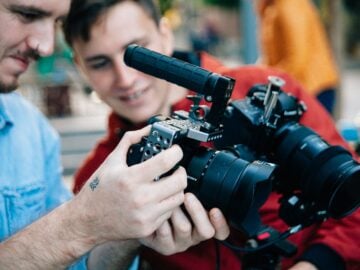 person holding and looking on black DSLR camera