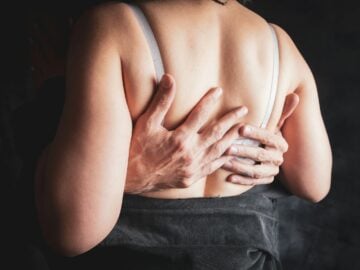Hands embracing a woman's back