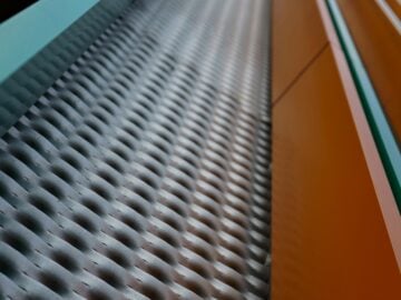 A metal grate and orange wall are visible.