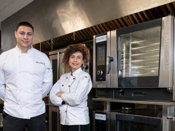 a couple of people standing in front of some ovens