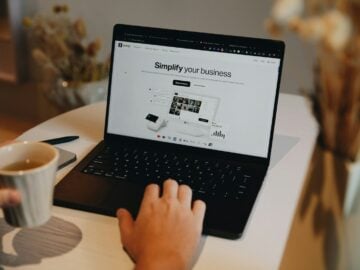 A person sitting at a table using a laptop computer