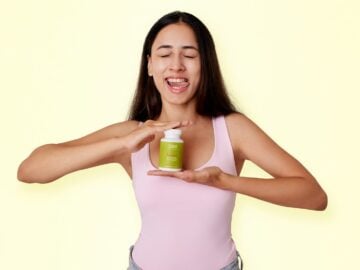 A woman holding a jar of green stuff
