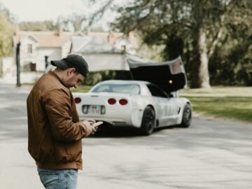 a man standing in the street looking at his cell phone