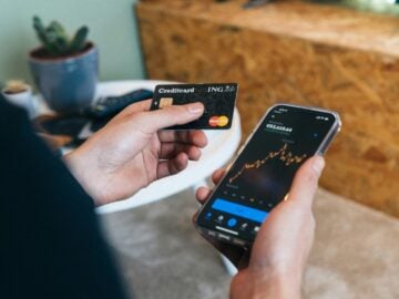 a person holding a smart phone and a credit card