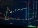 A digital candlestick chart showing cryptocurrency market trends on a dark computer screen