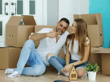 Couple sitting among moving boxes in new home